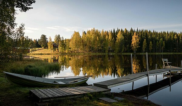 Ruhiger See mit Steg und Boot in Finnland
