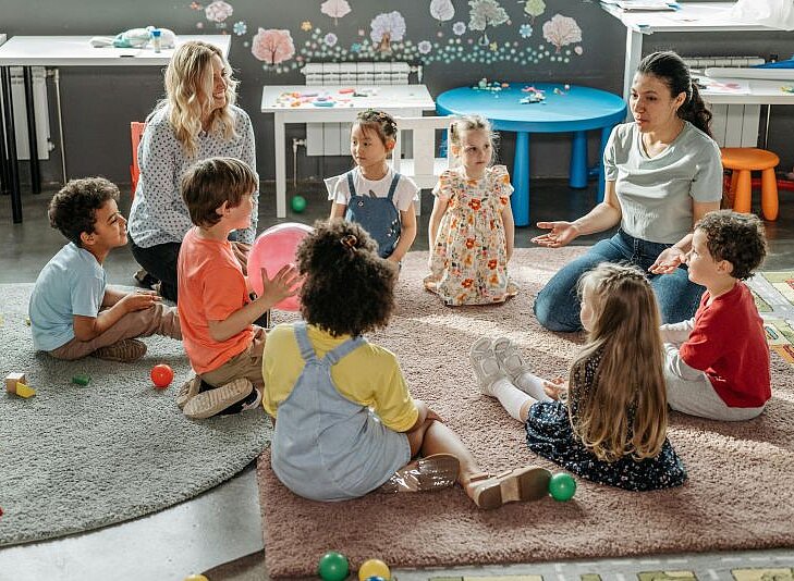 Gruppe von Kindern sitzt im Kindergarten