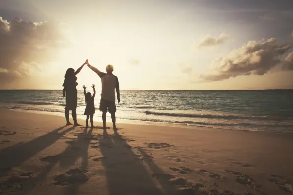 Familie gemeinsam am Strand im Sonnenaufgang