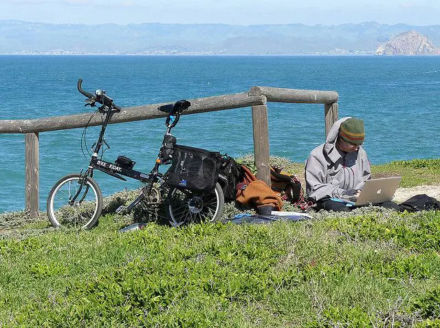 Mann mit einem Laptop am See