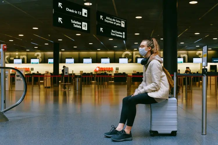 Junge Frau mit Mundschutz am Flughafen