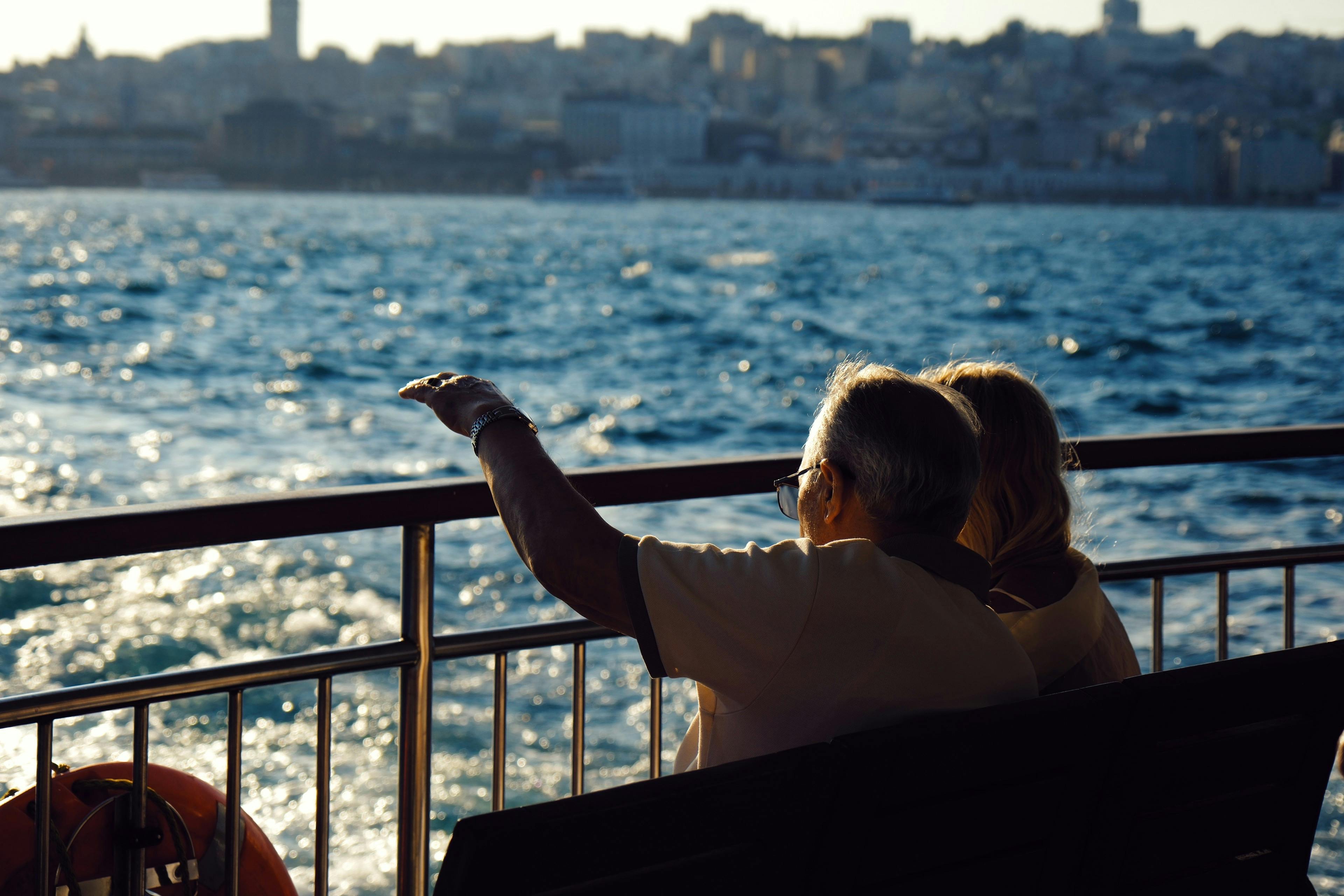 Zwei Senioren sitzen auf Bank am Meer