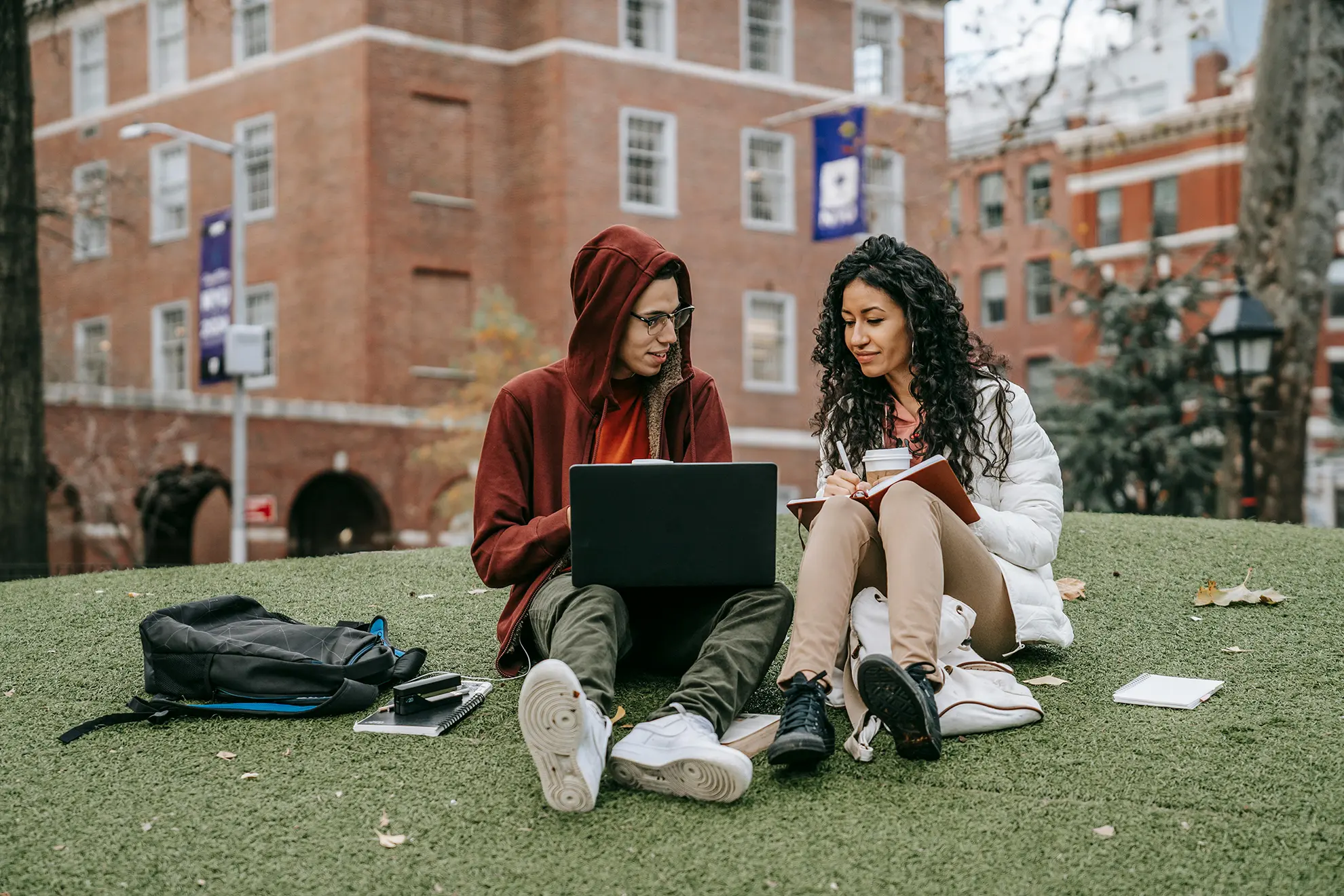 Studierende mit Notebook vor der Universität